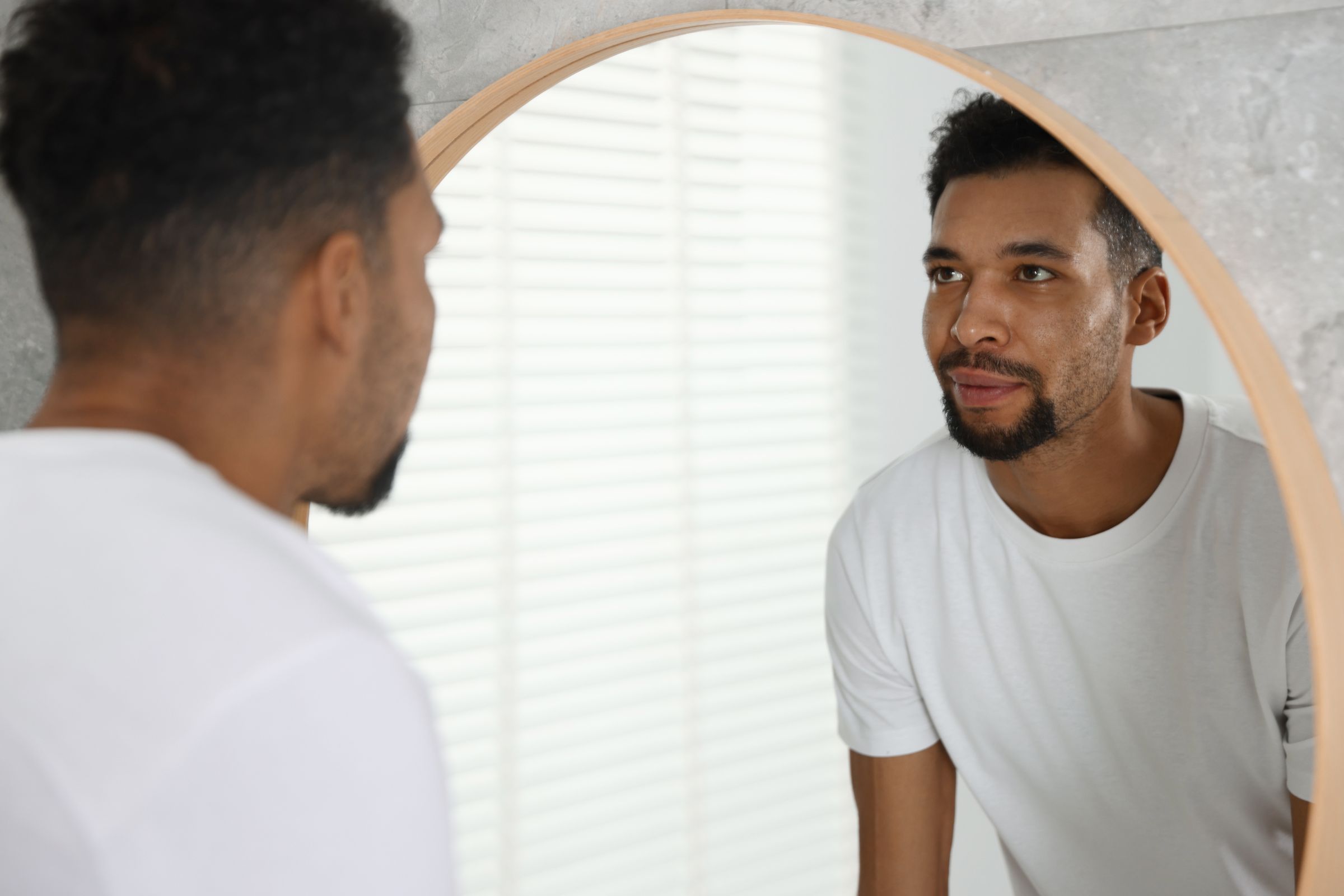 Man looking in bathroom mirror